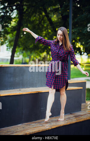 Girl does pirouette walking on a tiptoes against summer park. Stock Photo