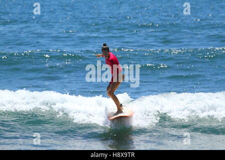 A woman in her thirties surfing a longboard at Moffat Beach on the Sunshine Coast in Queensland, Australia. Stock Photo