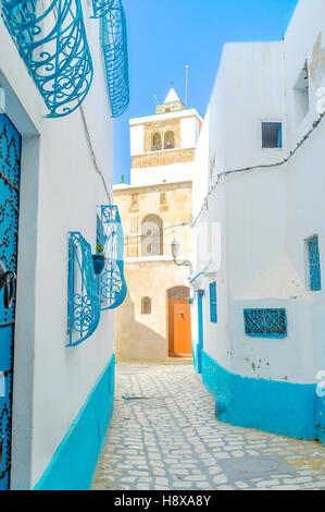 The view on the old minaret from the narrow street of Medina, Bizerte, Tunisia. Stock Photo