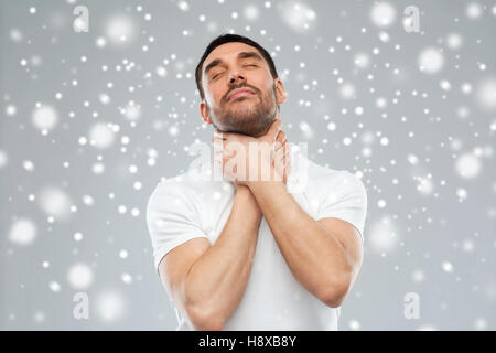 young man choking himself over snow background Stock Photo