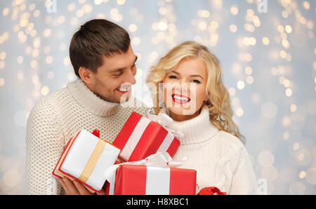 smiling man and woman with presents over lights Stock Photo