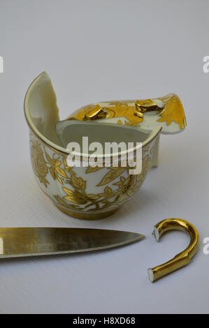 Broken cup of tea, and knife. Stock Photo