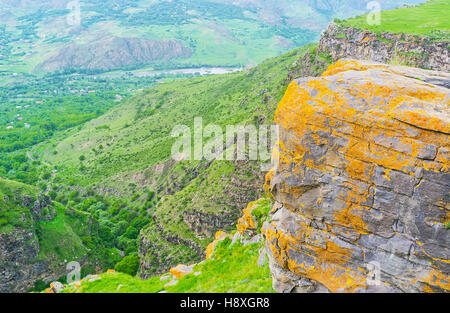 The boulders and rocks in mountain village of Saro covered with bright yellow and orange lichen, Georgia. Stock Photo