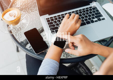 woman using smart watch in coffee shop, modern city lifestyle Stock Photo