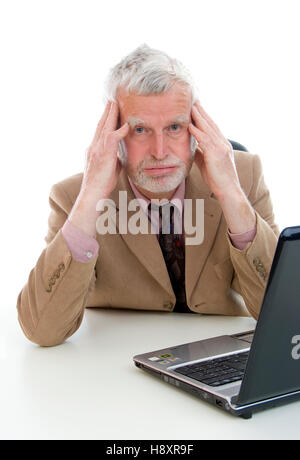 Elderly, overstrained businessman using laptop Stock Photo