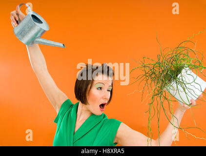 Young woman watering plant Stock Photo