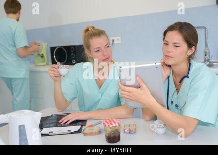 two medical coworkers looking at a tablet Stock Photo