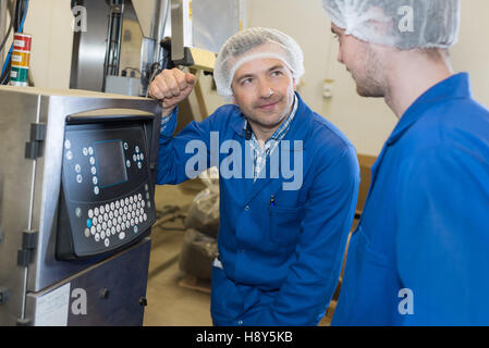 female apprentice working with engineer on cnc machinery Stock Photo