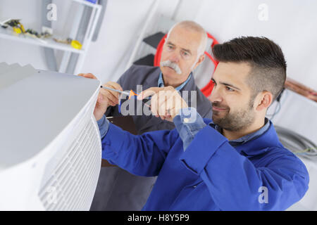 electrician and manager repairman fixing air conditioning Stock Photo
