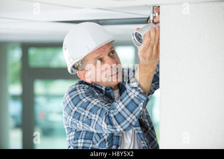 workman replacing guttering on exterior of house Stock Photo