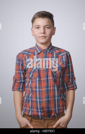 Teenager in shirt on a white background with a serious expression on his face. Stock Photo