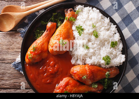 Thai cuisine: chicken leg with spicy chilli sauce Sriracha and Rice close-up on a plate. horizontal view from above Stock Photo