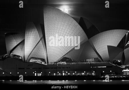 Sydney, Australia - 15 November 2016: Super full moon rising over Sydney Opera House in Australia during unique astronomy event after sunset in dark n Stock Photo
