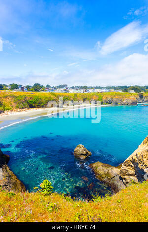 Beautiful azure cove below the cliffs near Main Street on a blue sky day in Mendocino community in California. Vertical Stock Photo