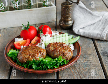 fried cutlets in plate with vegetables on wooden table put on a plate Stock Photo