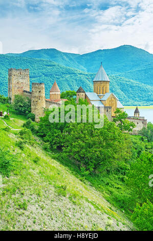 The old stone towers and Assumption Church's dome of Ananuri Castle among the greenery on the steep slope at Aragvi River, Mtskheta-Mtianeti, Georgia. Stock Photo