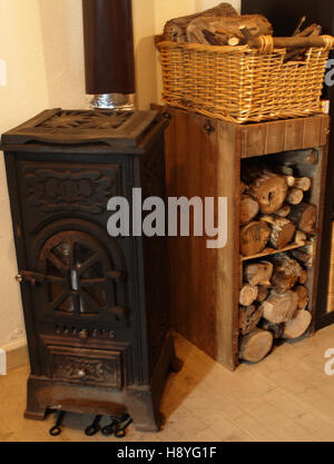Wood burning stove with rustic log store Stock Photo