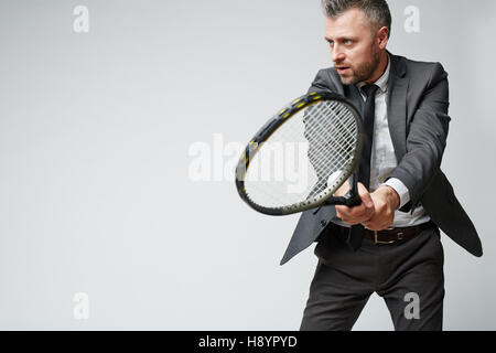 Man in formalwear playing tennis Stock Photo