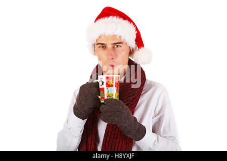 Handsome young man in scarf and Santa's hat, holding christmas cup Stock Photo