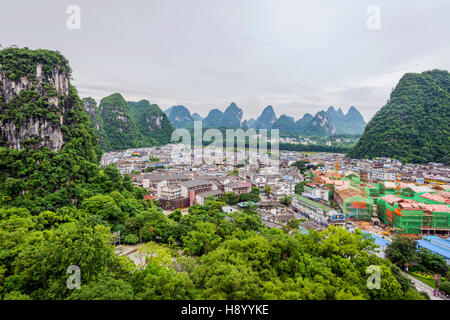 YANGSHUO, CHINA - JUNE 12: View over skyline of Yangshuo surrounded with recognizable karst landscape. Karst mountains are the biggest tourist attract Stock Photo