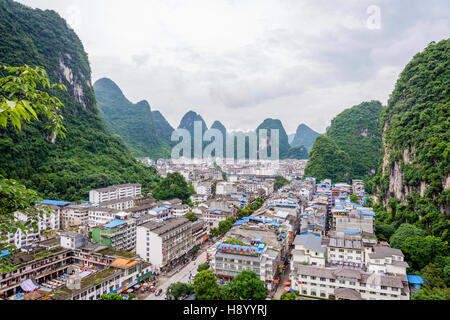 YANGSHUO, CHINA - JUNE 12: View over skyline of Yangshuo surrounded with recognizable karst landscape. Karst mountains are the biggest tourist attract Stock Photo