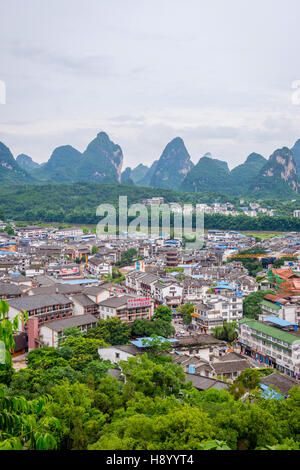 YANGSHUO, CHINA - JUNE 12: View over skyline of Yangshuo surrounded with recognizable karst landscape. Karst mountains are the biggest tourist attract Stock Photo