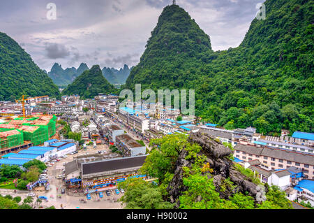 YANGSHUO, CHINA - JUNE 12: View over skyline of Yangshuo surrounded with recognizable karst landscape. Karst mountains are the biggest tourist attract Stock Photo