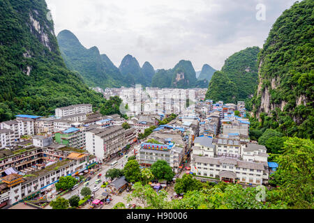 YANGSHUO, CHINA - JUNE 12: View over skyline of Yangshuo surrounded with recognizable karst landscape. Karst mountains are the biggest tourist attract Stock Photo