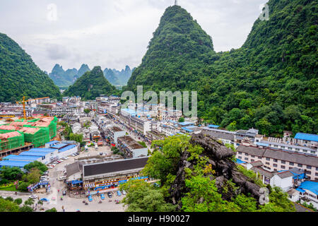 YANGSHUO, CHINA - JUNE 12: View over skyline of Yangshuo surrounded with recognizable karst landscape. Karst mountains are the biggest tourist attract Stock Photo