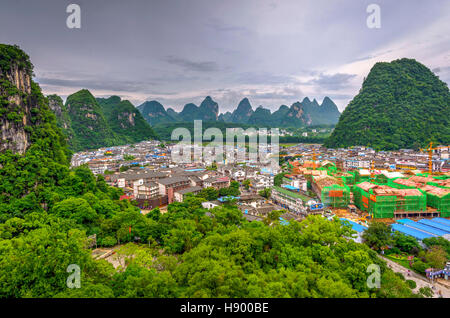 YANGSHUO, CHINA - JUNE 12: View over skyline of Yangshuo surrounded with recognizable karst landscape. Karst mountains are the biggest tourist attract Stock Photo