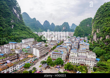 YANGSHUO, CHINA - JUNE 12: View over skyline of Yangshuo surrounded with recognizable karst landscape. Karst mountains are the biggest tourist attract Stock Photo