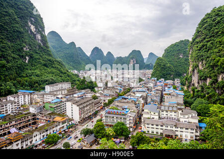 YANGSHUO, CHINA - JUNE 12: View over skyline of Yangshuo surrounded with recognizable karst landscape. Karst mountains are the biggest tourist attract Stock Photo