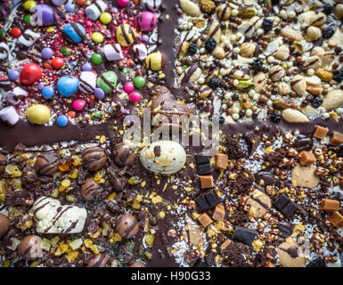 Easter explosive, abstract mix of chocolate, sweets and nuts around the shape of a cross. Stock Photo