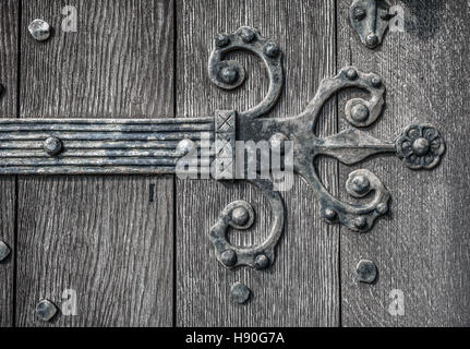 Ornate and weathered medieval church door hinge pattern. Stock Photo