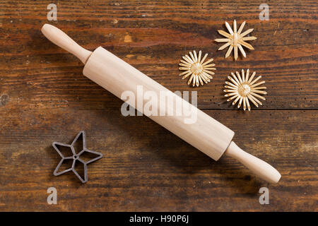 Rolling pin and baking pan and stars as background image for Christmas - top view still life arranged on weathered wooden board Stock Photo
