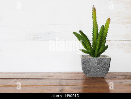 Pot of artificial plant decorated on wooden table Stock Photo