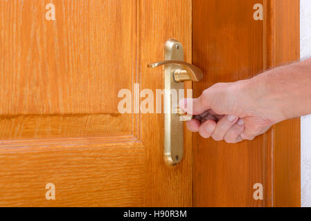 Opening or closing a safety lock on a wooden door Stock Photo