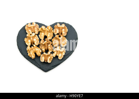 Walnuts on heart shaped black slate Stock Photo