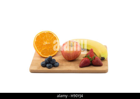 Half Orange with strawberries, blueberries, apple and banana on wooden board isolated on white background Stock Photo