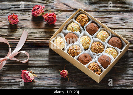 Box of delicious chocolates and pralines and dried pink roses. Valentine's day gift, Valentine day concept Stock Photo