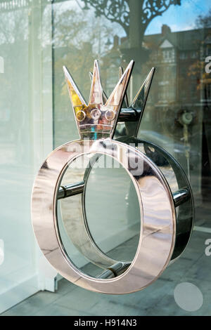 A Queen or King metallic door handle on shop entrance in Southport, Merseyside, UK Stock Photo