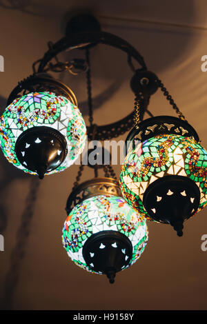 Colorful glass Turkish lamp hanging from the ceiling. Stock Photo