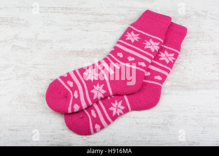 Pink woolen socks on white wooden background Stock Photo