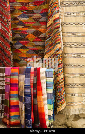 Rugs, carpets and scarves displayed outside a shop in the souk, Essaouira, Morocco Stock Photo