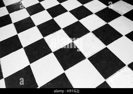 Vintage stone floor tiling with black and white checkered pattern Stock Photo