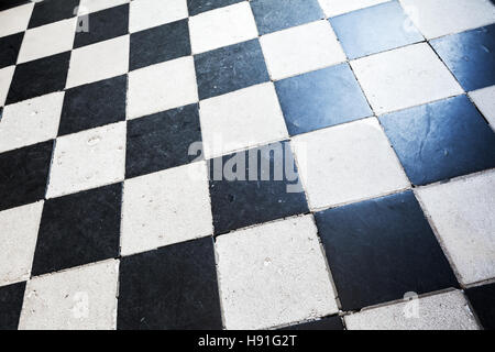 Old stone floor tiling with classical black and white checkered pattern Stock Photo