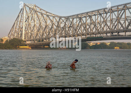 People take bath on river Hooghly (Ganges) near Howrah bridge close to Mallick ghat, Kolkata, India. Stock Photo