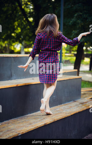 Girl does pirouette walking on a tiptoes against summer park. Stock Photo