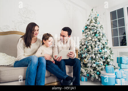 christmas, x-mas, winter, happiness, technology and people concept - smiling family with tablet pc Stock Photo