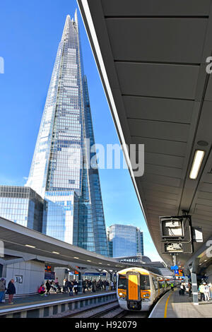 Shard London landmark UK skyscraper building towering over infrastructure of refurbished London Bridge station railway track platforms and train Stock Photo